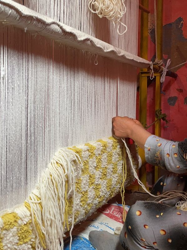 Tisseuse au travail sur un métier vertical